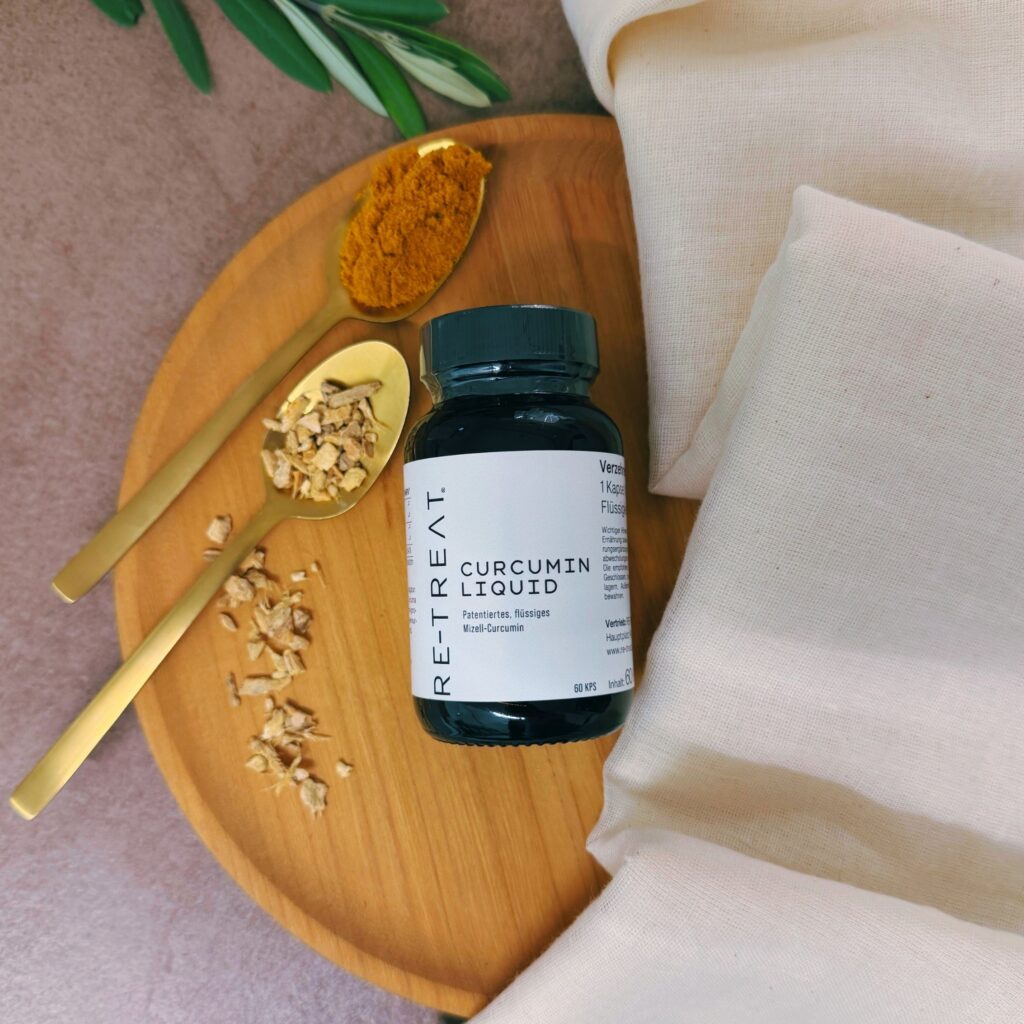 Curcumin Liquid Nahrungsergänzung auf einem Holzteller mit Kurkuma und Ingwer in einem goldenen Löffel, Baumwolltuch und Olivenzweig